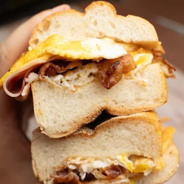 A close-up of a Harry's Hilltop deli breakfast sandwich with bacon, egg, and cheese.